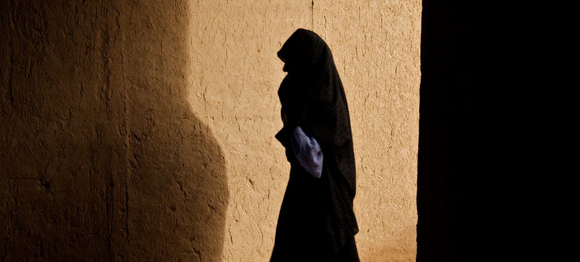 زنی در دهکده ای در ولسوالی زندهجان افغانستان از راهرو عبور می کند.  (فیله)