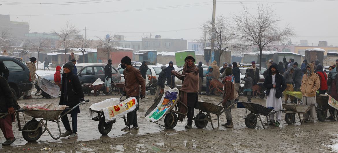 مردم در صف انتظار دریافت کمک های غذایی از WFP در کابل، افغانستان هستند.